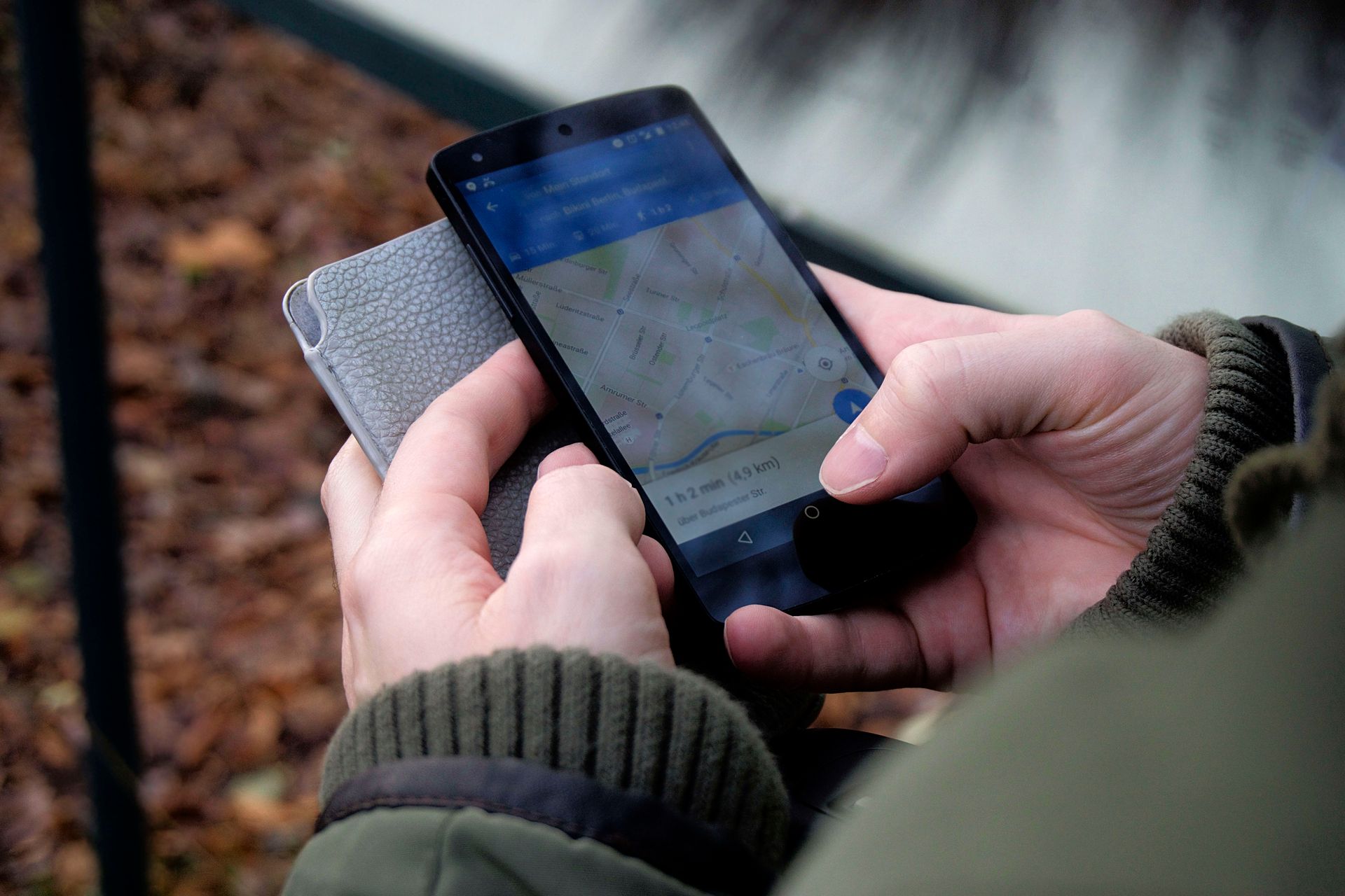 Mãos segurando um smartphone com o Google Maps aberto, calculando uma rota